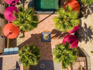 阿尔布费拉Vila Origens Boutique Hotel Albufeira – Adults Only的享有棕榈树和遮阳伞的建筑的顶部景色