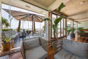 罗萨斯Hotel Maritim的一个带椅子的客厅和一个植物阳台