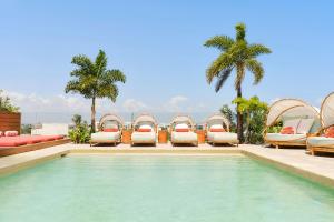 普拉亚卡门CALIXTA Hotel的一个带躺椅的游泳池以及度假村