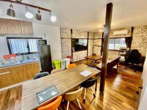 宇都宫ARS HOTEL Utsunomiya フロア貸切的厨房以及带木桌和椅子的用餐室。