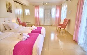 卡西奥皮Villa Spiros Imerolia Kassiopi的粉红色和白色的客房内的两张床