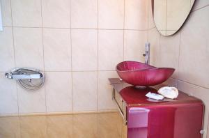 卡西奥皮Villa Spiros Imerolia Kassiopi的浴室装有手提箱顶上的碗水槽