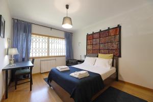 加亚新城FLH Gaia Valadares Comfy Apartment的一间卧室配有一张床、一张桌子和一张四柱床。