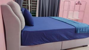 浮罗山背PRESTIJ H0MESTAY的床上有蓝色毯子