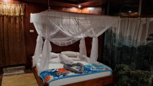 武吉拉旺武吉拉旺山地度假酒店的天蓬床,上面有一个人