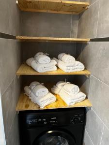 科尔特Casa Petra SALGA的洗衣机旁的架子上放着一大堆毛巾