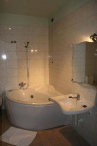 雷焦艾米利亚阿利罗尼酒店的浴室设有白色浴缸和水槽。
