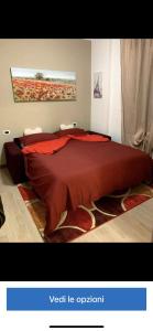 帕代诺杜尼亚诺Appartamento “La Corte”的一间卧室配有一张大床和红色的床罩