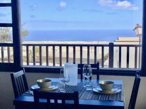 阿索马达Las Casitas Rusticas的桌椅和玻璃杯,享有海景
