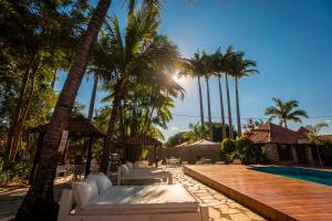 皮雷诺波利斯Pousada Villa das Pedras的一个带游泳池和棕榈树的度假村