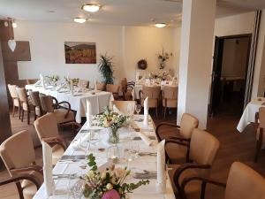 埃登科本普法尔茨餐厅酒店的餐厅设有白色的桌椅和鲜花