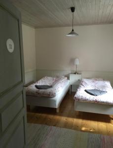 VintrosaHallagårdens B&B的一间卧室配有两张床和一盏灯。