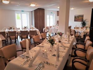 埃登科本普法尔茨餐厅酒店的配有桌椅和白色桌布的房间