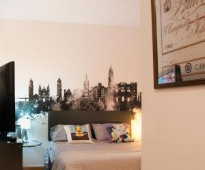 马拉加MalagaOlé Centro的卧室配有一张挂有城市壁画的床。