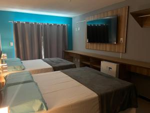 马塞约Pousada Paradise Vista do Atlantico的酒店客房设有两张床和一台平面电视。