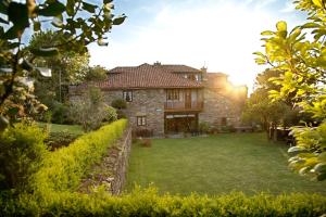塞代拉Casa Rural Cordobelas的一座大型石头房子,前面设有一个花园