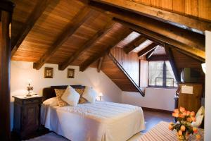 塞代拉Casa Rural Cordobelas的一间带一张床的卧室,位于带木制天花板的房间内
