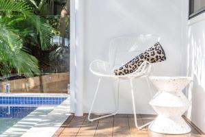 努萨角BERRIMA LUXE - Noosa Hill Home - Heated Pool的一张带豹纹印鞋的白色椅子