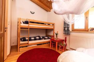 昆德尔Haus Evelin的一间卧室配有双层床,铺有红色地毯。