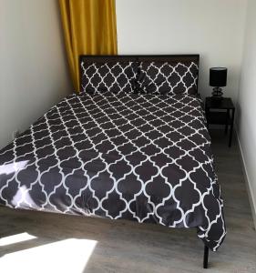 桑塞尔Sancerre Sunflower - Tournesol de Sancerre的一间卧室配有一张带黑白色床罩的床。