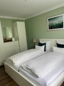 弗罗伊登施塔特Blackforest Apartment的一间卧室配有一张带白色床单的大床