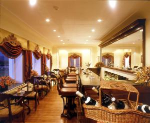 斯利那加拉利特大皇宫斯利那加酒店的餐厅设有酒吧,配有桌椅