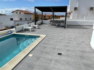 塔拉哈勒赫Villa Neila, Fuerteventura的庭院设有游泳池、桌子和椅子。
