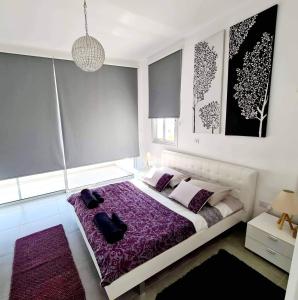 帕福斯Leonidas VILLA的一间卧室配有一张大床和紫色毯子