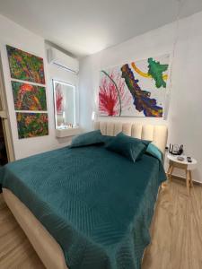 伏罗拉Sunny breeze apartment的卧室配有一张床,墙上挂有两幅画