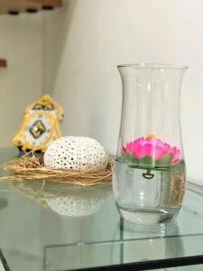 墨西拿Vecchia Paradiso - A un passo dal Mare的玻璃瓶,坐在玻璃桌旁,花在上面
