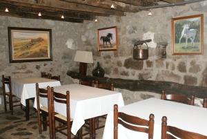 Oix灿培乡村民宿的一间用餐室,配有两张桌子和墙上的绘画作品