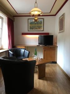 维安登Bed & Breakfast du Château的客厅配有桌椅和电视。