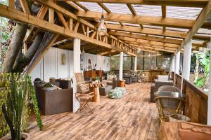 安加罗阿黑尔努亚精品酒店的铺有木地板,设有带沙发和椅子的带顶棚天井。