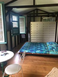 Saint-JosephCharmant bungalow avec piscine的卧室配有1张床、1张桌子和1把椅子