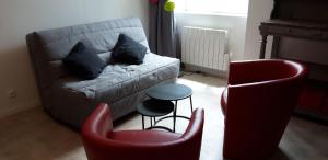 BaugéTriplex tout confort, plein centre ville Bauge en Anjou的客厅配有沙发和两把椅子