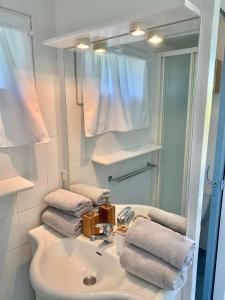 勒布斯卡Chambre cosy indépendante dans jardin verdoyant.的浴室配有盥洗盆、镜子和毛巾