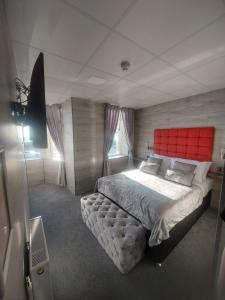布莱克浦Kings Boutique Hotel的一间卧室配有一张大床和红色床头板