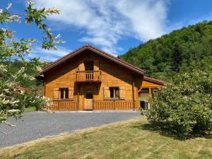 普兰凡Gîte Chalet avec bain nordique et piscine 11 pers Hautes Vosges的小木屋前设有阳台