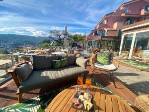 因佩里亚Villa Giada Resort的一张沙发,坐在甲板上,配有桌子