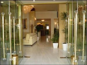 底比斯梅乐提欧酒店的客厅配有白色沙发和玻璃柜