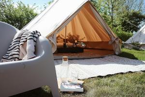 Jubbega-SchuregaBell Tent Parc Bûten Jubbega的帐篷配有桌子和一瓶葡萄酒