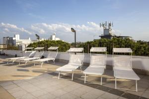 里乔内Hotel Luana的坐在屋顶上的一排白色椅子