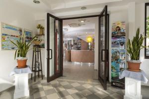里乔内Hotel Luana的大厅,有门和两盆植物