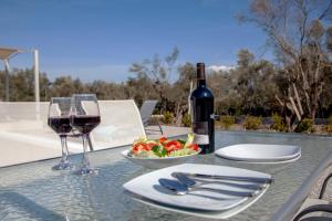利吉亚Naiades Villas的一张桌子,上面放着一杯葡萄酒和一碗水果