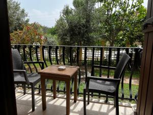萨利杰尔梅韩精品酒店 的阳台的门廊配有三把椅子和一张桌子