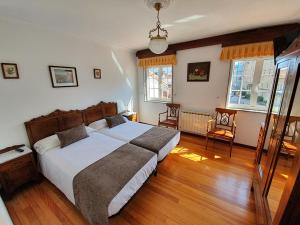 圣地亚哥－德孔波斯特拉吉亚达斯旅馆的一间卧室设有一张大床,铺有木地板。