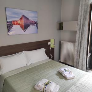 拉奎拉La Terrazza del Quarto的一间卧室配有一张床,上面有两条毛巾