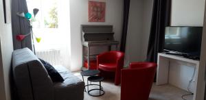 BaugéTriplex tout confort, plein centre ville Bauge en Anjou的客厅配有沙发、两把椅子和电视