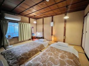 奈良奈良町宾馆的一间卧室设有两张床和窗户。
