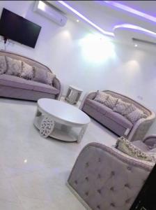 Ithnaynفلل فندقية بمدينة تنومة的客厅配有紫色沙发和桌子